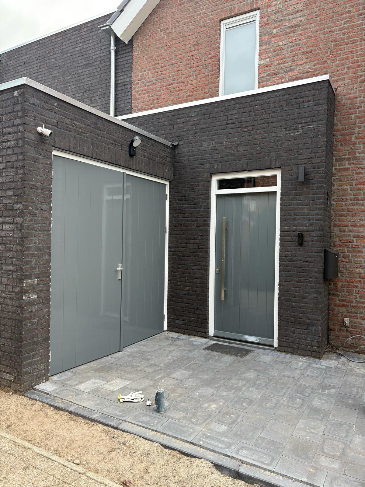 Buitenschilderwerk, waarbij garagedeur en voordeur met hoogglans afgelakt bij een vrijstaande woning in Stiphout